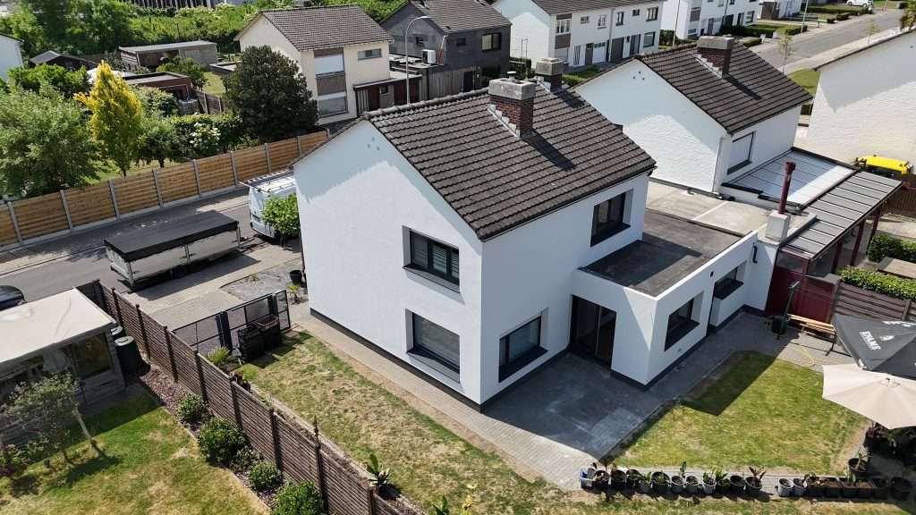 Zijgevel van gerenoveerde woning in Oudenaarde met egale crepi-afwerking in lichte kleur.